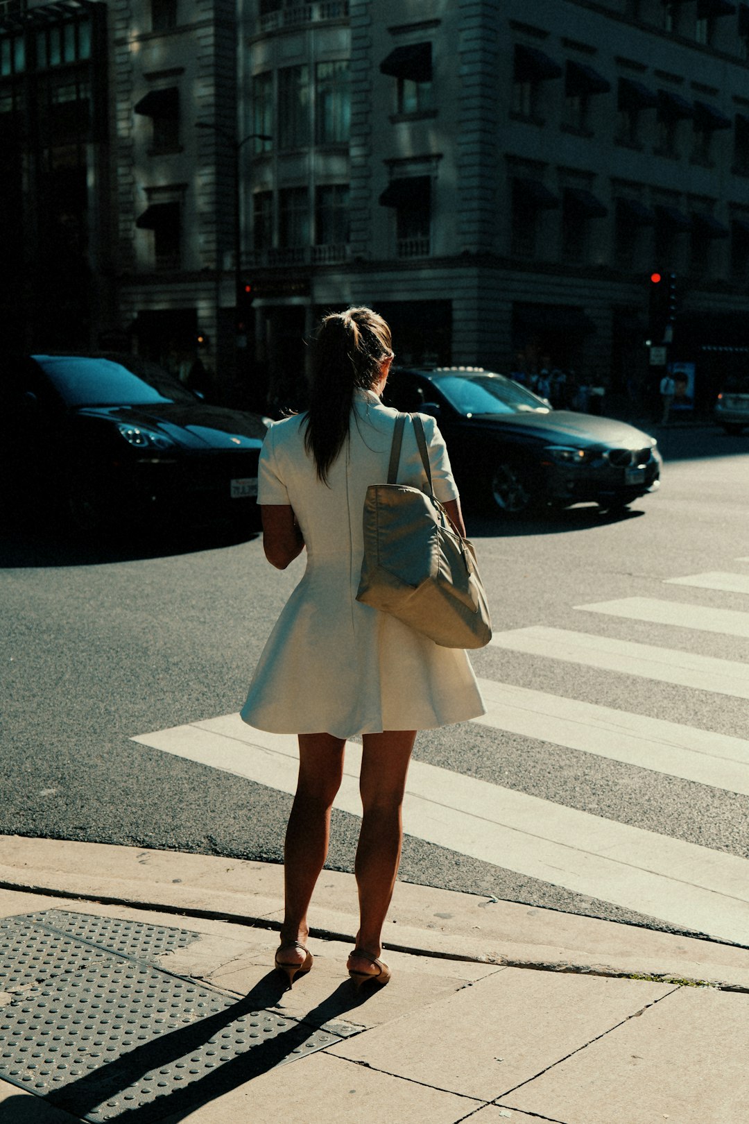 woman-in-white-dress-waits-at-a-crosswalk-kovgjqplclc